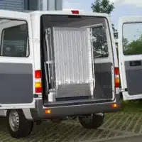 Hinteransicht eines Lieferwagens mit offener Schiebetür und ausklappbarer Rampe aus Aluminium für einen barrierefreien Zugang.