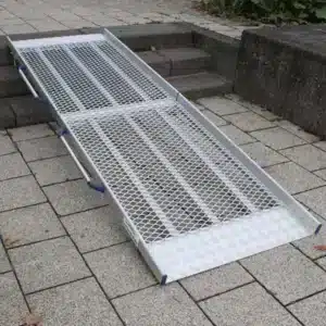 Aluminiumrampe mit Gitterstruktur zum Überwinden von Stufen, geeignet für Rollstühle oder Gehhilfen, platzsparend und stabil.