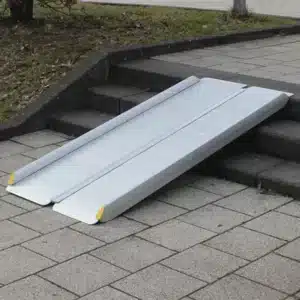 Rollstuhlrampe aus Aluminium mit rutschfester Oberfläche, platziert auf einer Treppe, um den Zugang zu erleichtern.