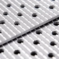 Nahaufnahme einer Rampen-Oberfläche mit parallelen Rillen und runden Löchern, geeignet für sichere Anwendungen.