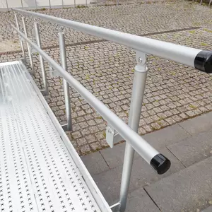 Ein Handlauf aus Aluminium ist an einer Rollstuhlrampe montiert
