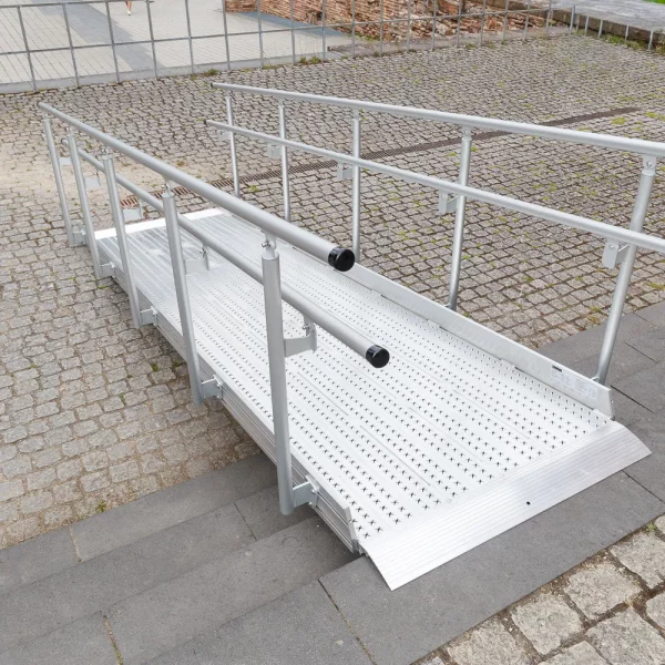 Eine Rollstuhlrampe aus Metall mit Handläufen