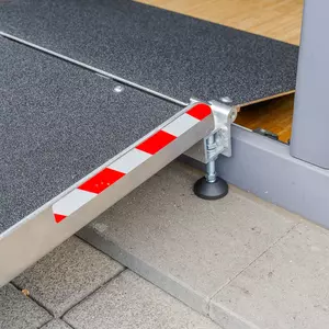 Eine rot-weiß gestreifte Markierung an einer Balkon- und Terrassenbrücke für Rollstuhlfahrer