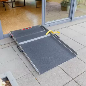 Eine tragbare Rollstuhlrampe ist an einer Tür angebracht