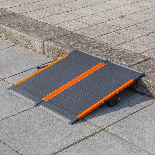 Eine tragbare schwarz-orangefarbene Rollstuhlrampe