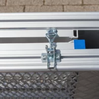 Nahaufnahme eines an einer Aluminium-Rollstuhlrampe befestigten Metallriegelschlosses.