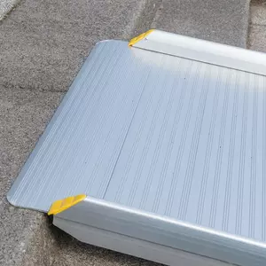 Nahaufnahme des oberen Auflagewinkels einer tragbaren Aluminium-Rollstuhlrampe auf einer Betonstufen