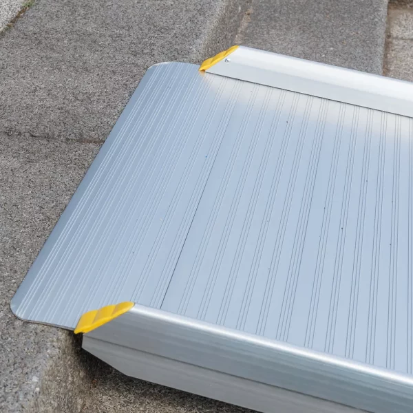 Nahaufnahme des oberen Auflagewinkels einer tragbaren Aluminium-Rollstuhlrampe auf einer Betonstufen