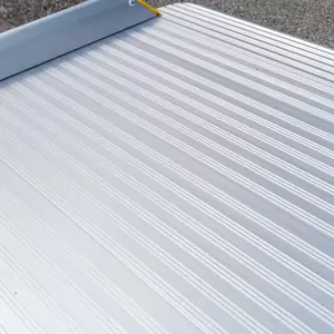 Nahaufnahme der rutschsicher geriffelten Fahrfläche einer Rollstuhlrampe aus Aluminium auf einer Betonfläche