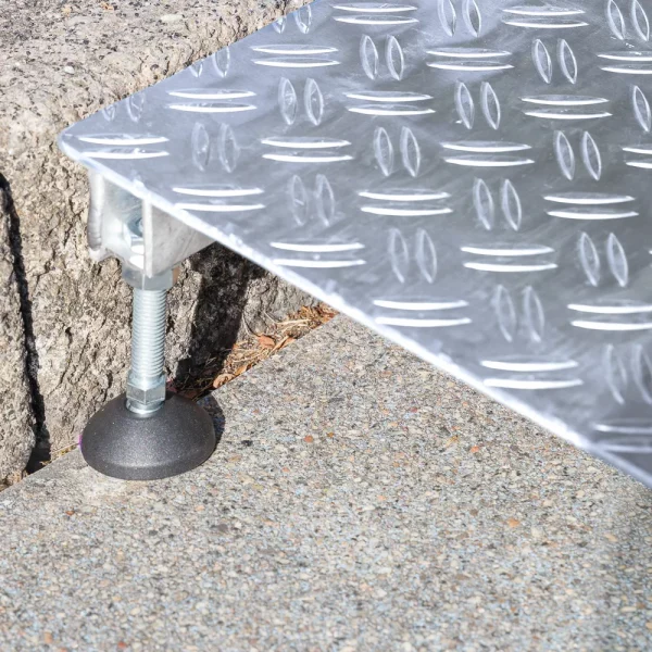 Nahaufnahme des verstellbaren Fußes einer Alumnium Rollstuhlrampe zur Überbrückung einer einzelnen Stufe.