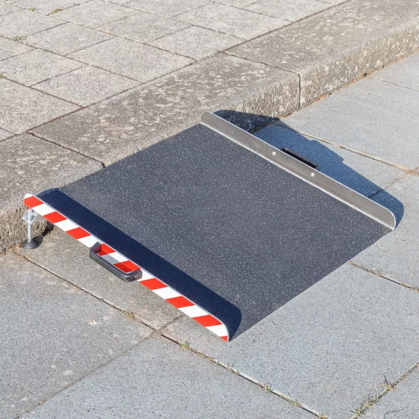 Eine tragbare Aluminium-Rollstuhlrampe mit rot-weiß gestreiften Rändern
