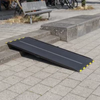 Eine schwarze Rollstuhlrampe aus Carbon mit gelben Rändern