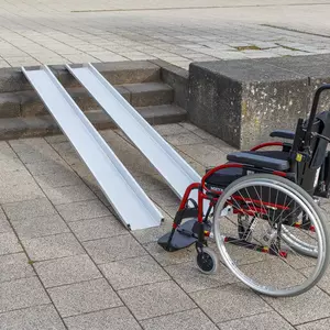 Ein roter Rollstuhl steht am unteren Ende von zwei Schienen einer Rollstuhlrampe