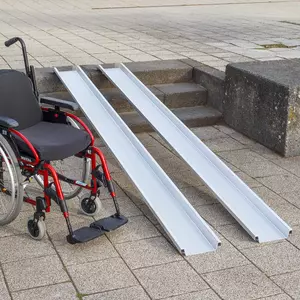 Ein roter Rollstuhl steht links neben zwei Schienen einer Rollstuhlrampe