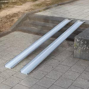 Zwei Schienen einer Rollstuhlrampe ist über einer Betontreppe im Außenbereich platziert