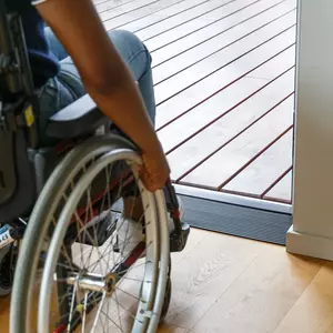 Eine Person im Rollstuhl nähert sich einer Tür