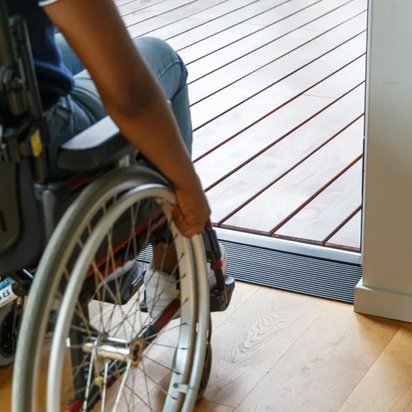 Eine Person im Rollstuhl nähert sich einer Tür