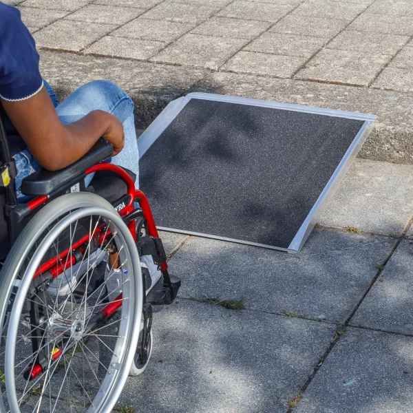 Eine Person im Rollstuhl nähert sich einer tragbaren Rampe