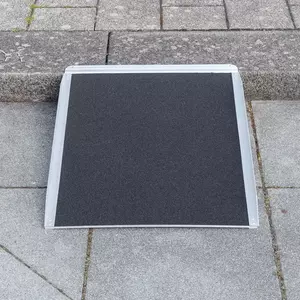 Eine tragbare Rollstuhlrampe auf einem Bordstein