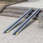 Eine zweiteilige Rollstuhlrampe mit schwarzer Oberfläche