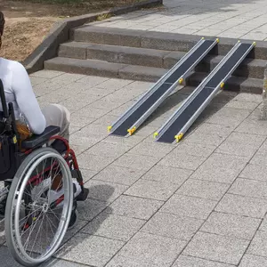 Eine Person im Rollstuhl steht vor zwei tragbaren Rampen