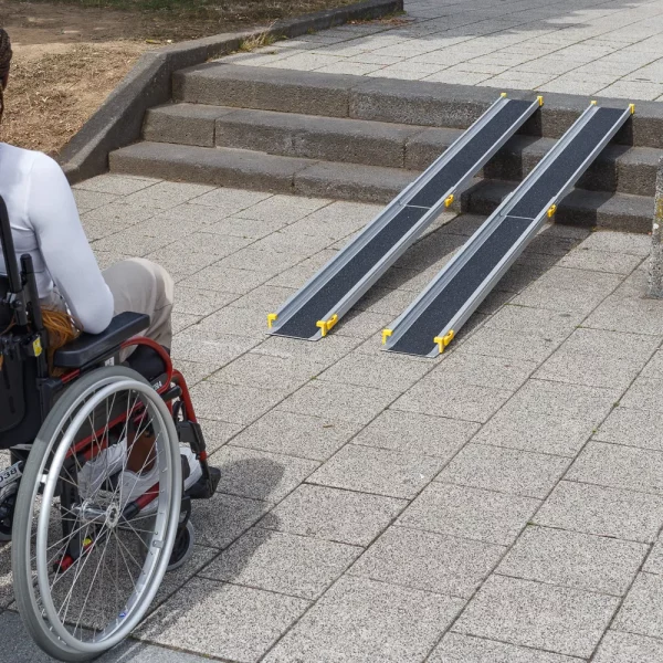 Eine Person im Rollstuhl steht vor zwei tragbaren Rampen