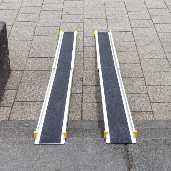 Zwei tragbare Rollstuhlrampen aus Aluminium mit rutschfester schwarzer Oberfläche sind auf einer Treppe platziert und verbinden zwei Ebenen miteinander.